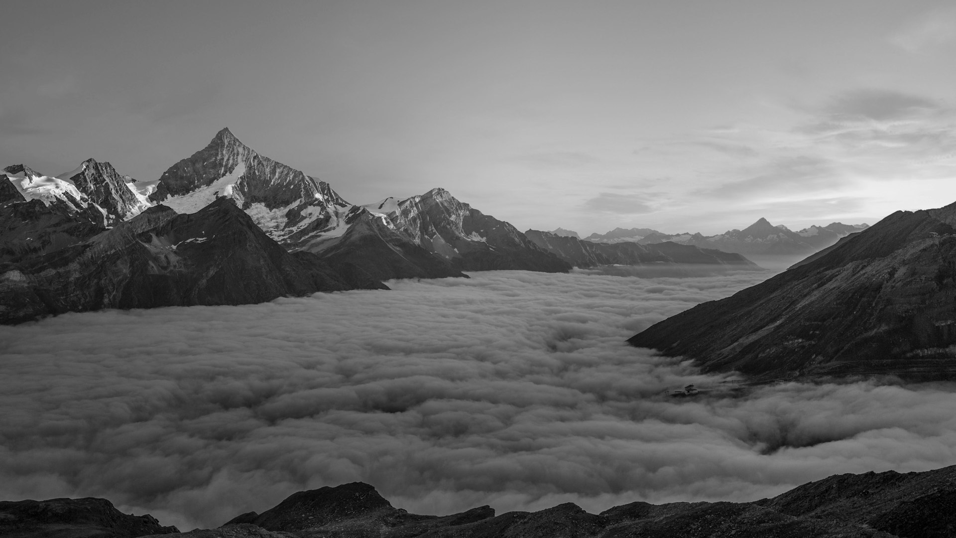 Vast grayscale mountain range with cloud formations - representing the comprehensive scope and enterprise scale of iCIMS Talent Cloud platform